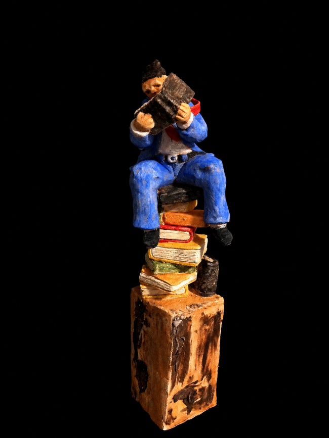 Figurina lettrice su libri colorati